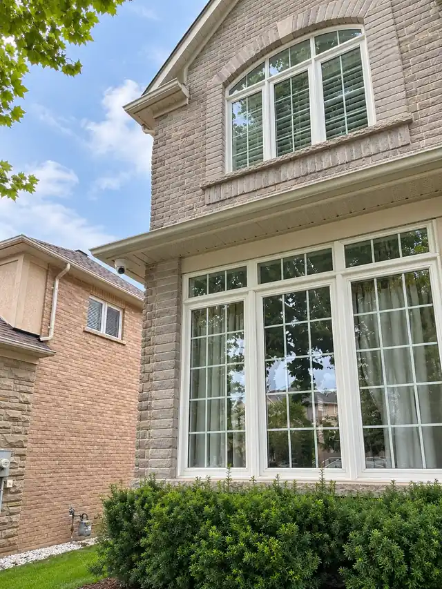 Security camera under the eaves of a two-storey brick home